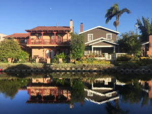 houses reflected in water at California’s Venice Canals in Venice, California